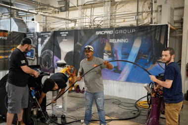 Hands-on trenchless training session with trainees handling lining equipment and using the UV XAIR during a pipe rehabilitation demonstration.